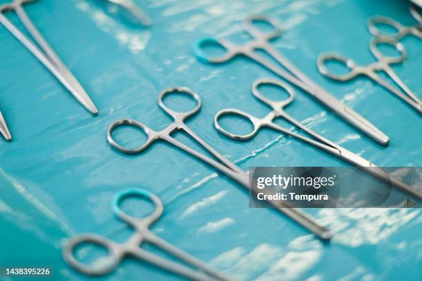 surgical instruments clearly laid out on sterile plastic table covering in operating room - forceps stock pictures, royalty-free photos & images