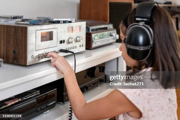 a girl is listening to a tape recorder - analog digital stock pictures, royalty-free photos & images