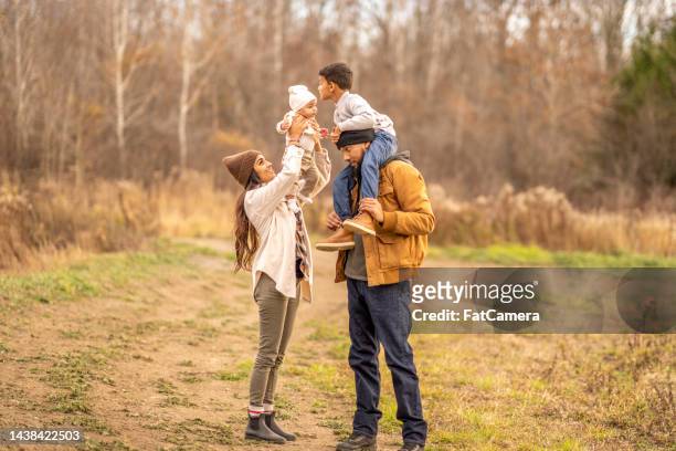 kissing baby sister - four people walking away stock pictures, royalty-free photos & images