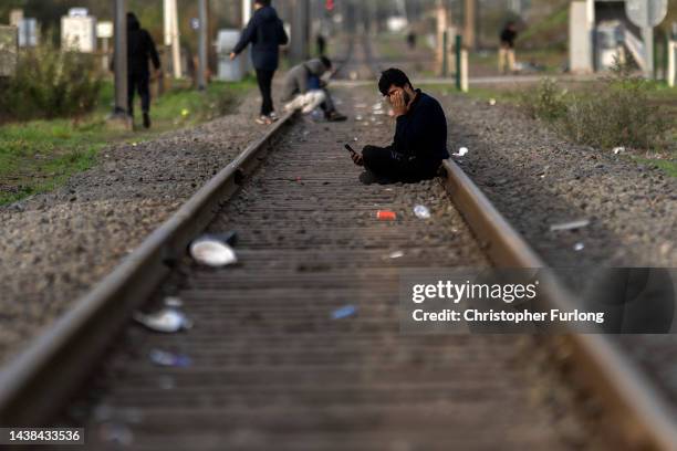 Refugees sit on railway tracks next to a distribution point run by the refugee crisis charity Care4Calais on November 02, 2022 in Dunkerque, France....