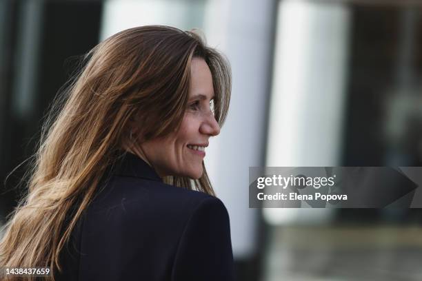 portrait young business woman walking on the street, side view, looking away - blue suit stock pictures, royalty-free photos & images