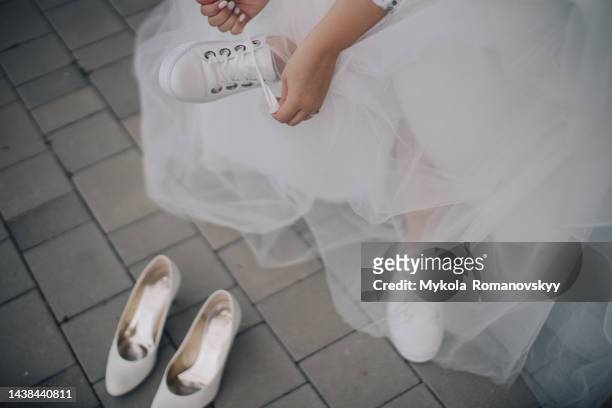 bride changing the shoes. - wedding shoes stock pictures, royalty-free photos & images