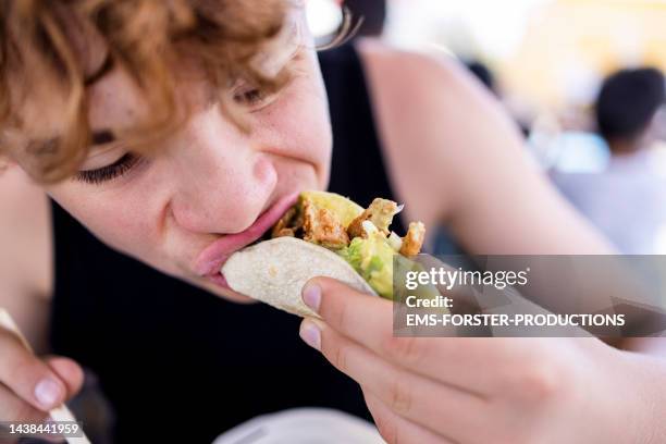 teenager boy is eating a chicken taco - salad to go stock pictures, royalty-free photos & images