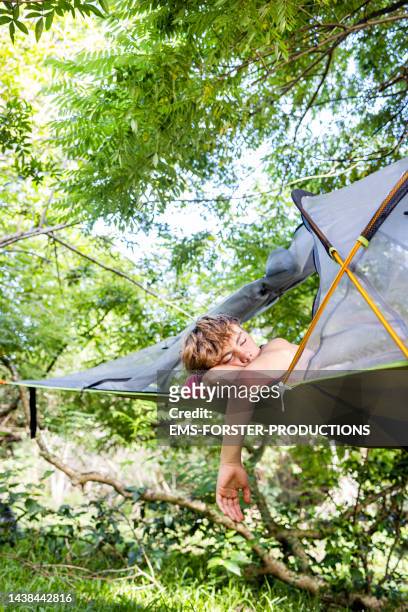 handsome teenager boy is sleeping on his flying hammock tent - handsome teen boy outdoors stock pictures, royalty-free photos & images