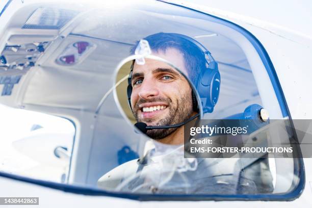 pilot of a small plane in cockpit wearing radio headset - beard pilot stock pictures, royalty-free photos & images