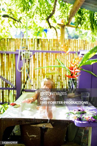 active, female senior is enjoying her bath in the jungle clamping place - foot nature green stock pictures, royalty-free photos & images