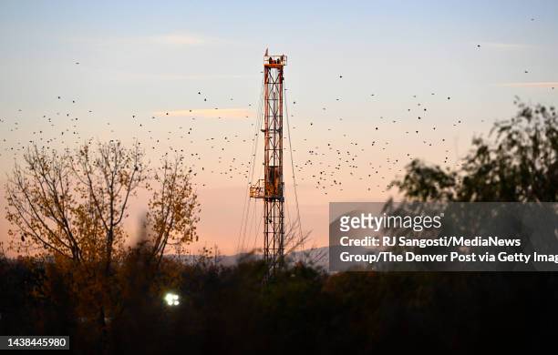 Birds fly past an oil and gas rig in Weld County on November 2, 2022 south of Greeley, Colorado. Greeleys economy hasn't recovered to pre-pandemic...