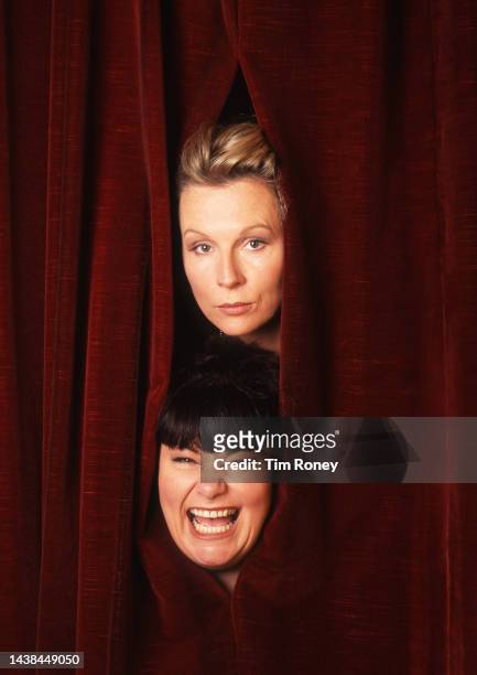 Portrait of British comedians and actors Dawn French and Jennifer Saunders, who performed as French and Saunders, as they look out between two...
