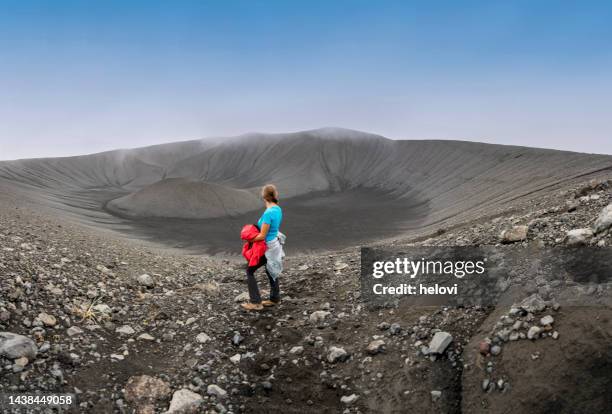 eine frau steht am rande des vulkans hverfjall - vulkankrater stock-fotos und bilder