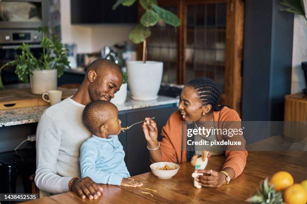 manger, bébé et les parents avec de la nourriture dans la cuisine de leur maison pour le petit déjeuner, le déjeuner ou le dîner. jeune, heureuse et mère souriante tout en nourrissant un enfant à une table avec amour de papa le matin - family smile photos et images de collection