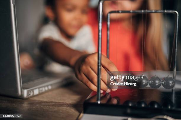 boy playing with newton's cradle - newtons cradle stock pictures, royalty-free photos & images