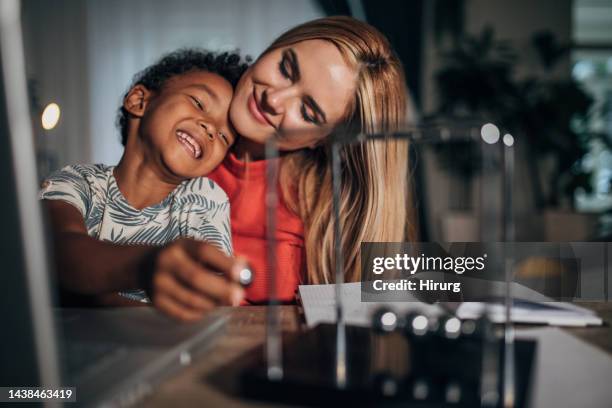 mother and son - newtons cradle stockfoto's en -beelden