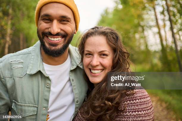 pareja joven riendo parada en un camino rural - couple portrait fotografías e imágenes de stock