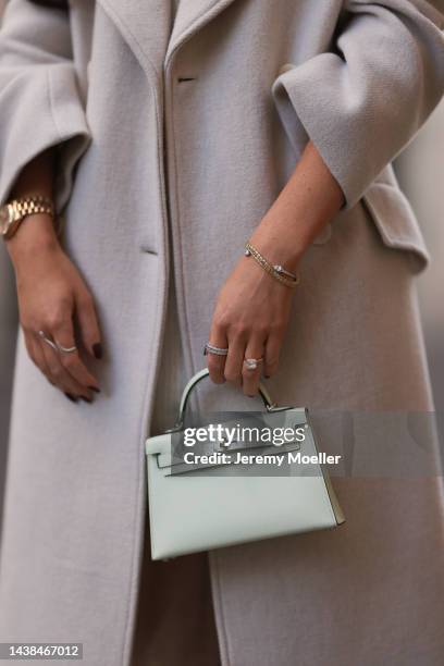 Leo Eberlin wearing Zara beige coat, H&M beige knit sweater dress, Hermes light green mini leather Kelly bag, Rolex gold Oyster Daydate watch and Leo...