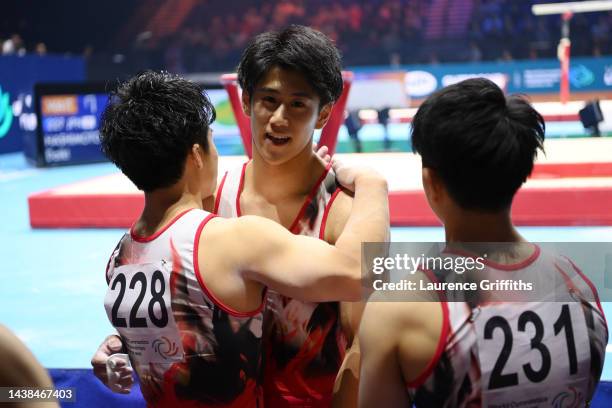 Daiki Hashimoto of Japan interacts with teammates Yuya Kamoto and Kakeru Tanigawa after their routine on Horizontal Bar during the Men's Team Final...