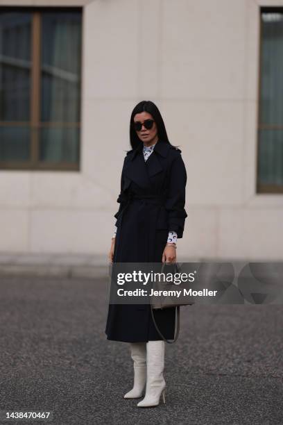 Leo Eberlin wearing Marine Serre black and white logo top, COS navy blue coat, Celine brown shades, Paris Texas beige leather boots, Hermes 25 brown...