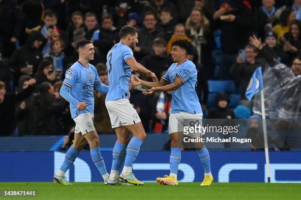 Rico Lewis of Manchester City celebrates with team mates Ruben Dias and Phil Foden after scoring their sides first goal during the UEFA Champions...