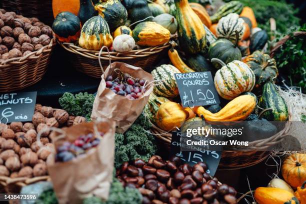 close-up of market stall selling various organic pumpkins and chestnuts - herbst kollektion stock-fotos und bilder