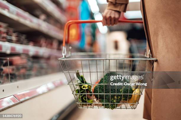 young woman shopping vegetables in supermarket - carrito de la compra fotografías e imágenes de stock