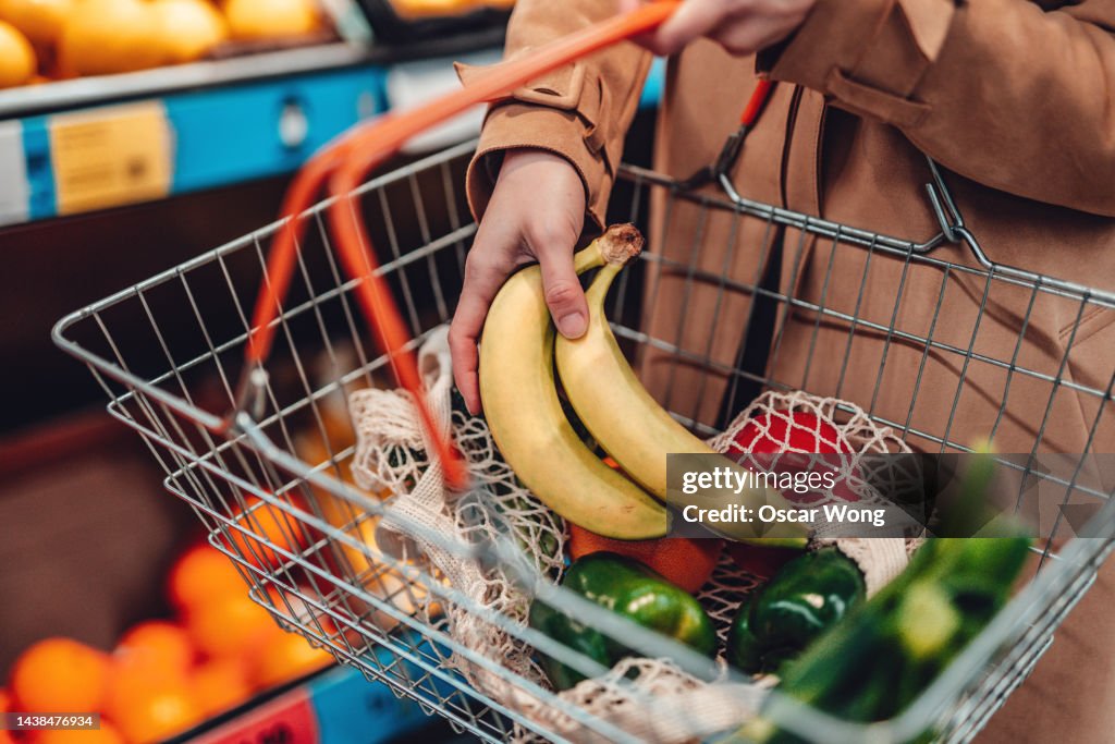Young woman shopping vegetables in supermarket
