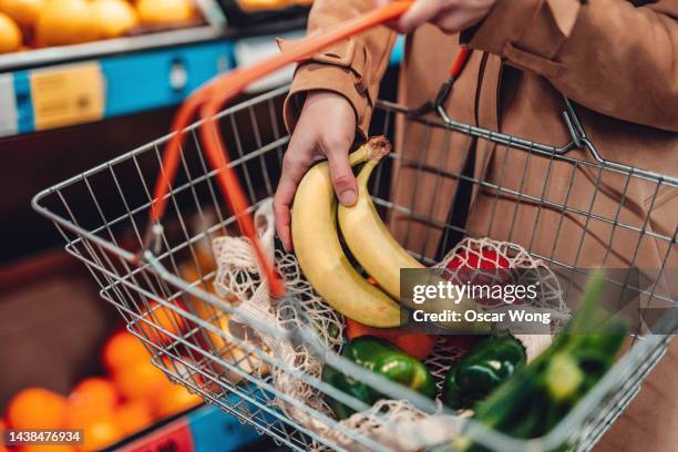 young woman shopping vegetables in supermarket - cesto de compras imagens e fotografias de stock