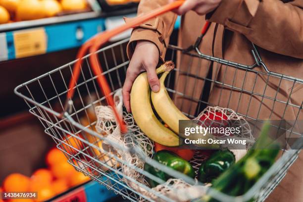 young woman shopping vegetables in supermarket - cesta de compras - fotografias e filmes do acervo