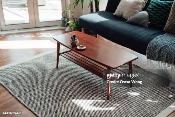 a mid-century style coffee table in a modern and stylish living room with sunlight - 鉢植え 無人 ストックフォトと画像