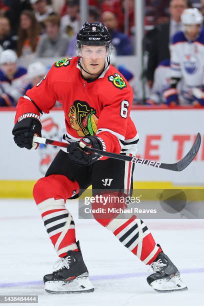 Jake McCabe of the Chicago Blackhawks controls the puck against the Edmonton Oilers during the first period at United Center on October 27, 2022 in...