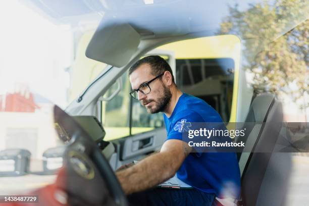 paramedic driving an ambulance - ambulance photos et images de collection