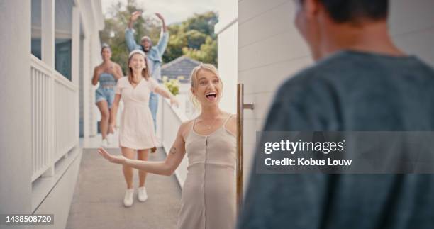 friends, party and front door as excited woman welcome man to house for surprise celebration, birthday or reunion gathering at entrance. group of people happy together with invitation to home - friends at the door stock pictures, royalty-free photos & images