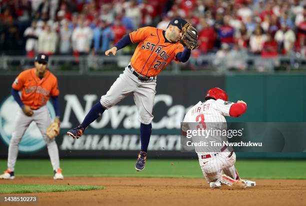 Bryce Harper of the Philadelphia Phillies steals second base past Jose Altuve of the Houston Astros during the second inning in Game Four of the 2022...