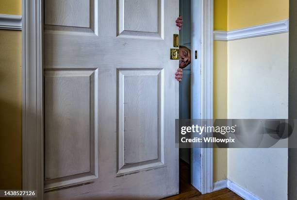 humorous old man peeking through cracked open doorway - staring stock pictures, royalty-free photos & images