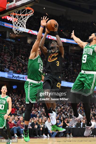 Caris LeVert of the Cleveland Cavaliers shoots over Grant Williams and Derrick White of the Boston Celtics during the third quarter at Rocket...
