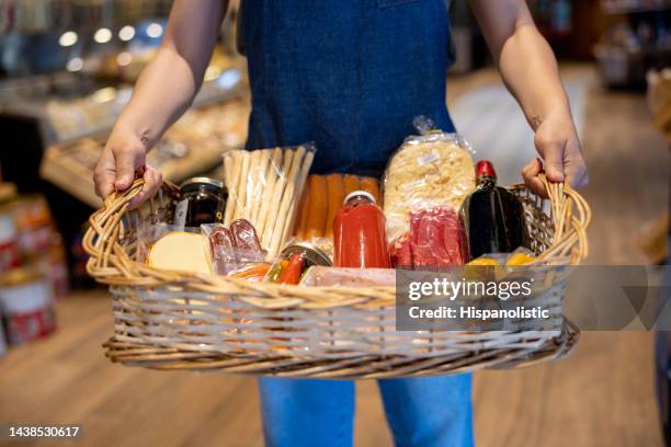 salesman working at a charcuterie and basket of food - deli counter stock pictures, royalty-free photos & images
