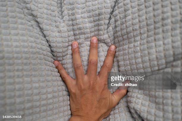 human hand touching blanket - human skin stock pictures, royalty-free photos & images