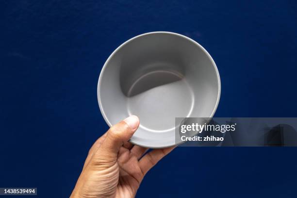human hand holding empty bowl - ciotola vuota foto e immagini stock