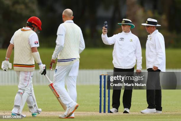 Umpires check the light levels just before a stoppage in play due to bad light during the Sheffield Shield match between New South Wales and South...