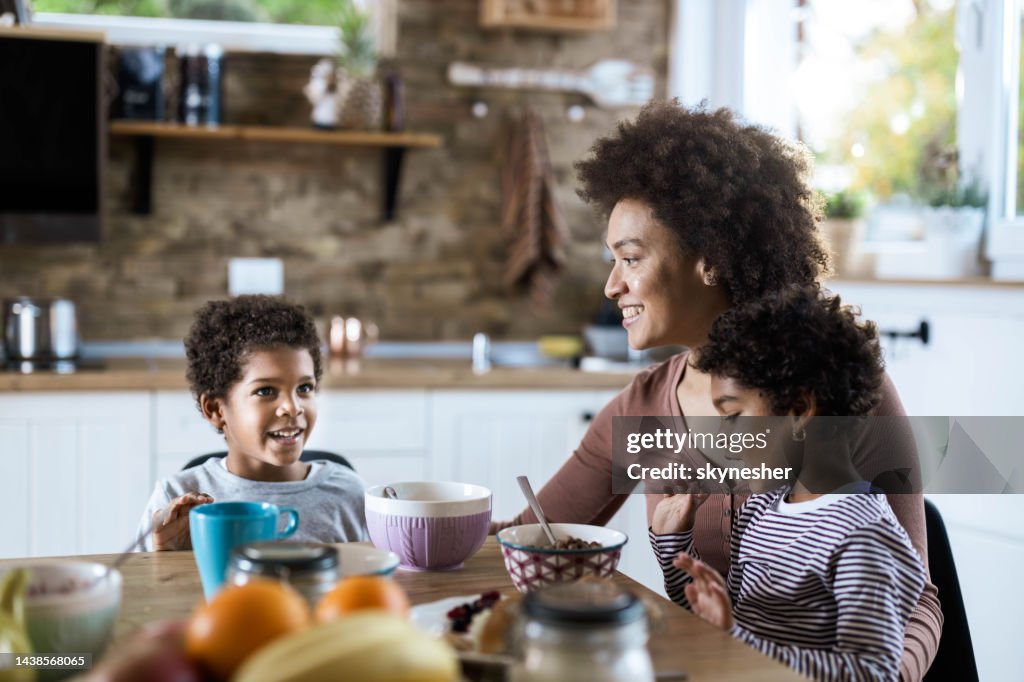 Single black mother enjoying with her kids during breakfast in the morning.