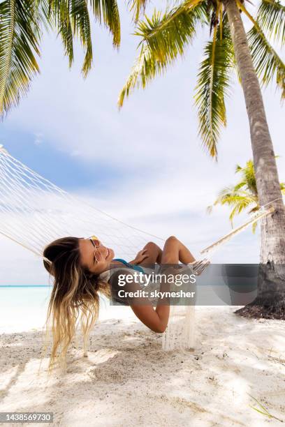 relaxed woman spending a summer day in hammock on the beach. - maldives beach stock pictures, royalty-free photos & images