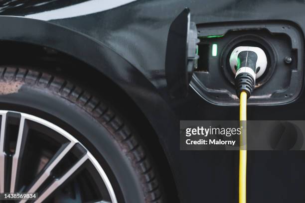 close-up of electric car charging. - chargers stock-fotos und bilder