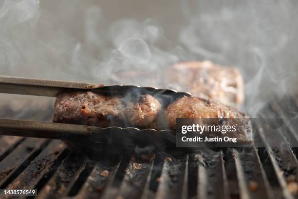 chef grilling meat with sizzling smoke - red meat stock pictures, royalty-free photos & images