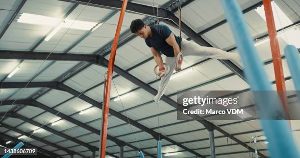 gymnastics ring, man and training arena for fitness, olympics and talent of professional champion in sports gym stadium. acrobat, athlete and strong body action training workout for power performance - gymnastics stock pictures, royalty-free photos & images