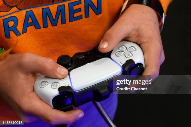 Gamer plays a video game with a video game controller, Sony DualSense for the Playstation 5 game console during Paris Games Week 2022 at Parc des...
