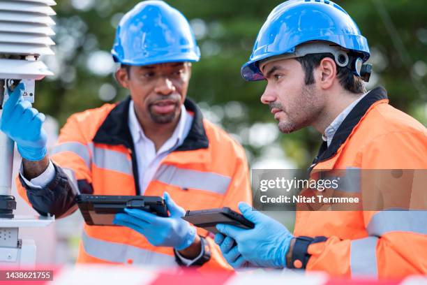 air pollution monitoring and environmental sustainability. diversity of team engineers in field operation of air quality monitoring having a discussion and collecting data of monitoring device at an air monitoring station outdoors. - nuclear waste management stock pictures, royalty-free photos & images