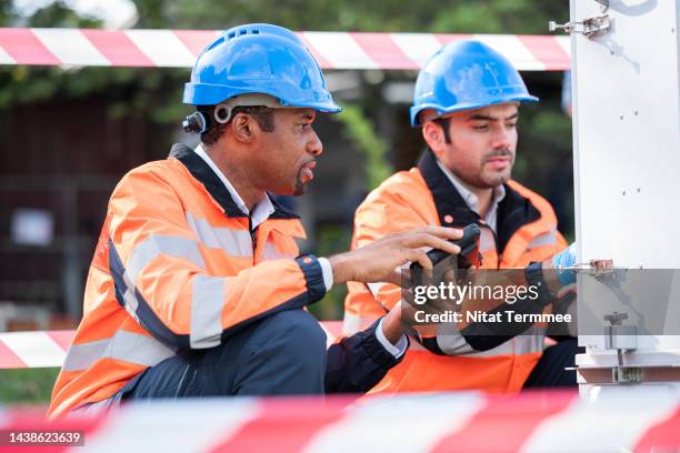 field operation of air quality monitoring. diversity of team engineers researching in the field and using a measuring device of air pollution at an air monitoring station. - measuring potential business stock pictures, royalty-free photos & images