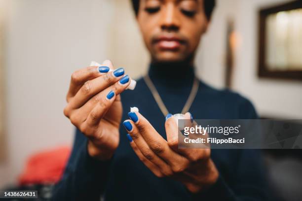 a non-binary person is using hand cream - non binary stereotypes stock pictures, royalty-free photos & images
