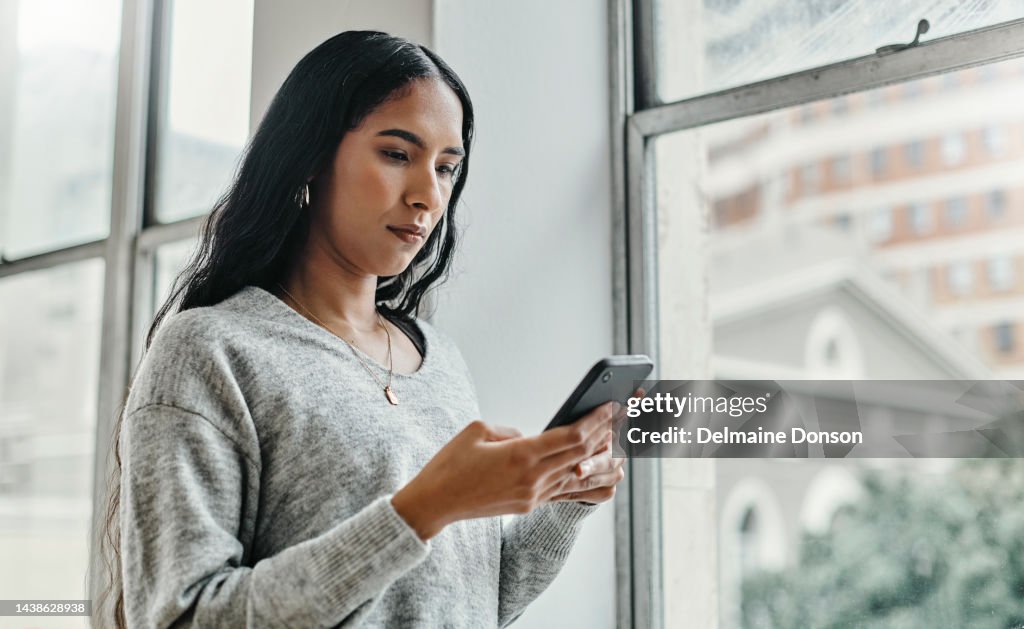 Search, news and phone with woman by window for social media, internet and communication. Contact, networking and app with girl and mobile at home thinking for digital, website and technology