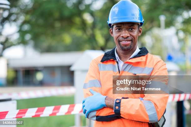 ambient air quality monitoring and testing in field operation. portrait of an african american meteorologist working at a mobile weather station or an air quality station to research air quality. - nuclear waste management stock pictures, royalty-free photos & images