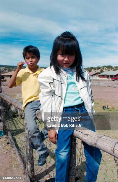 Neighborhood Navajo children Nicole Spenser and her brother Ross pass time blowing bubbles from fence during visit to Sheepherder Howard Jumbo home,...