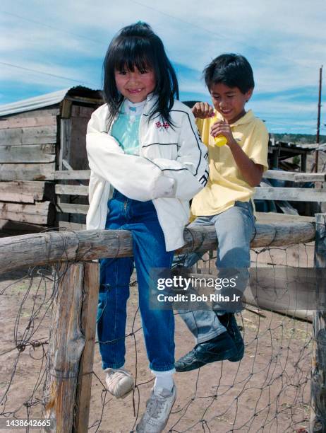 Neighborhood Navajo children Nicole Spenser and her brother Ross pass time blowing bubbles from fence during visit to Sheepherder Howard Jumbo home,...